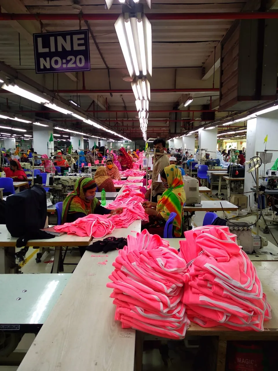 Pink garment batch moving down the sewing line